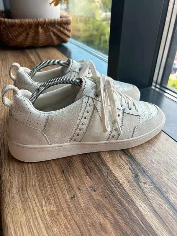 Białe skórzane sneakersy Maje ze srebrnymi nitami, dostępne w sklepie AVEXI, idealne do codziennych stylizacji.