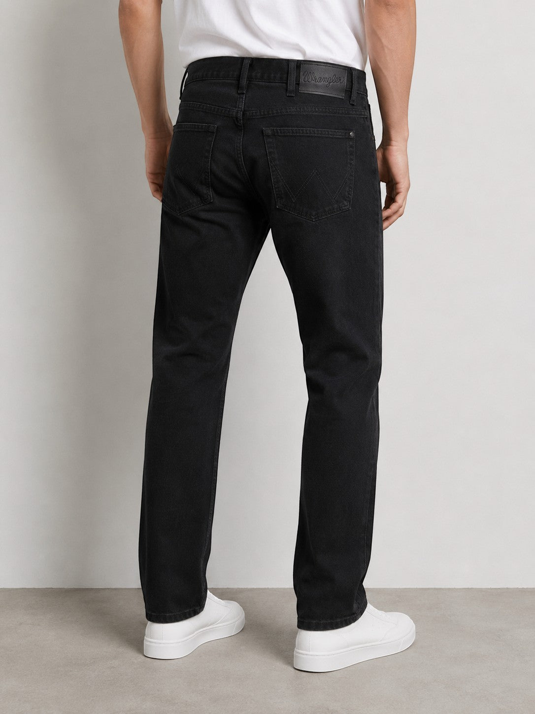 Męskie czarne jeansy Wrangler Arizona z oferty AVEXI, widok z tyłu na klasyczny krój z charakterystycznym przeszyciem