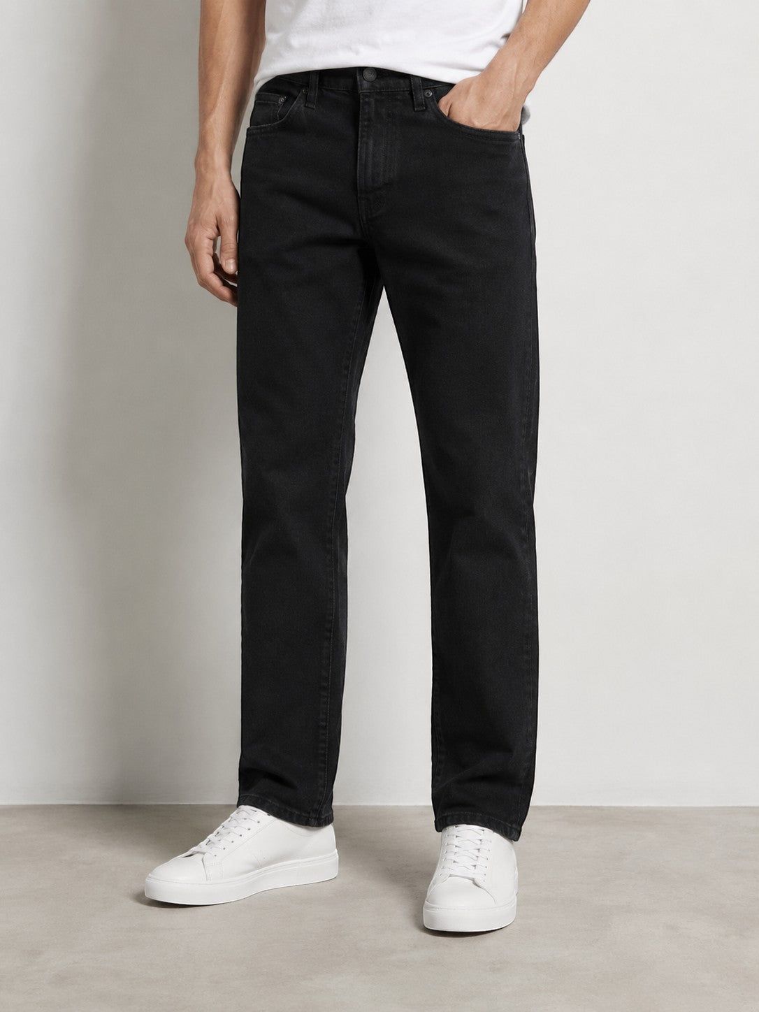 Męskie czarne jeansy Wrangler Arizona w sklepie AVEXI, klasyczny krój z bawełnianego denimu na modelu w białych butach