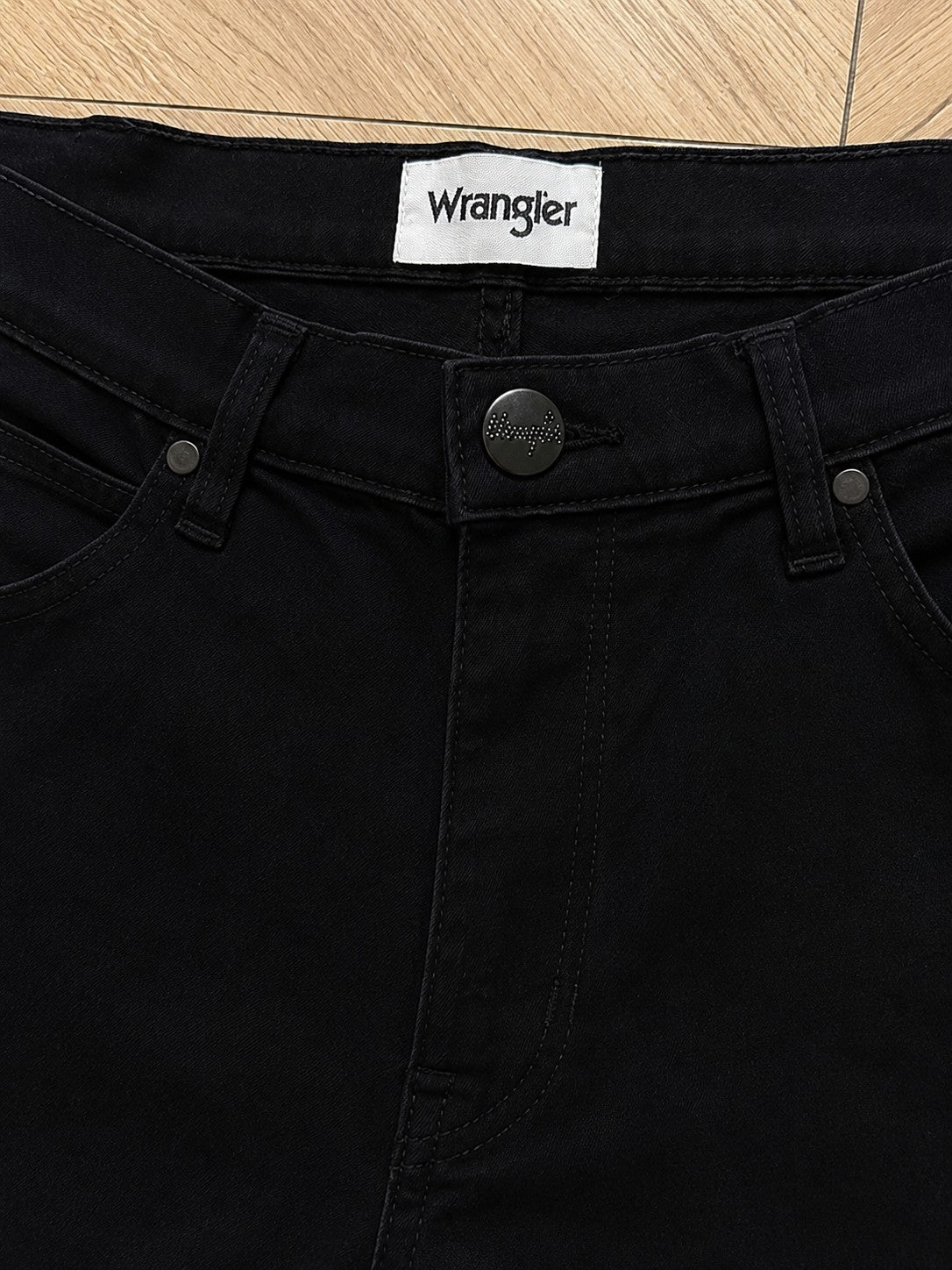 Czarne jeansy męskie Wrangler Arizona z logo marki AVEXI, klasyczny krój z metalowymi guzikami i nitami.